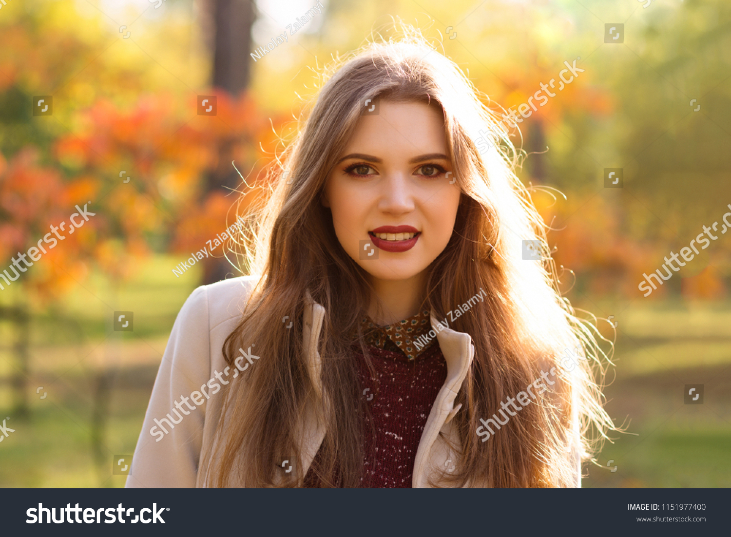 Portrait of smiling woman in autumn park #1151977400