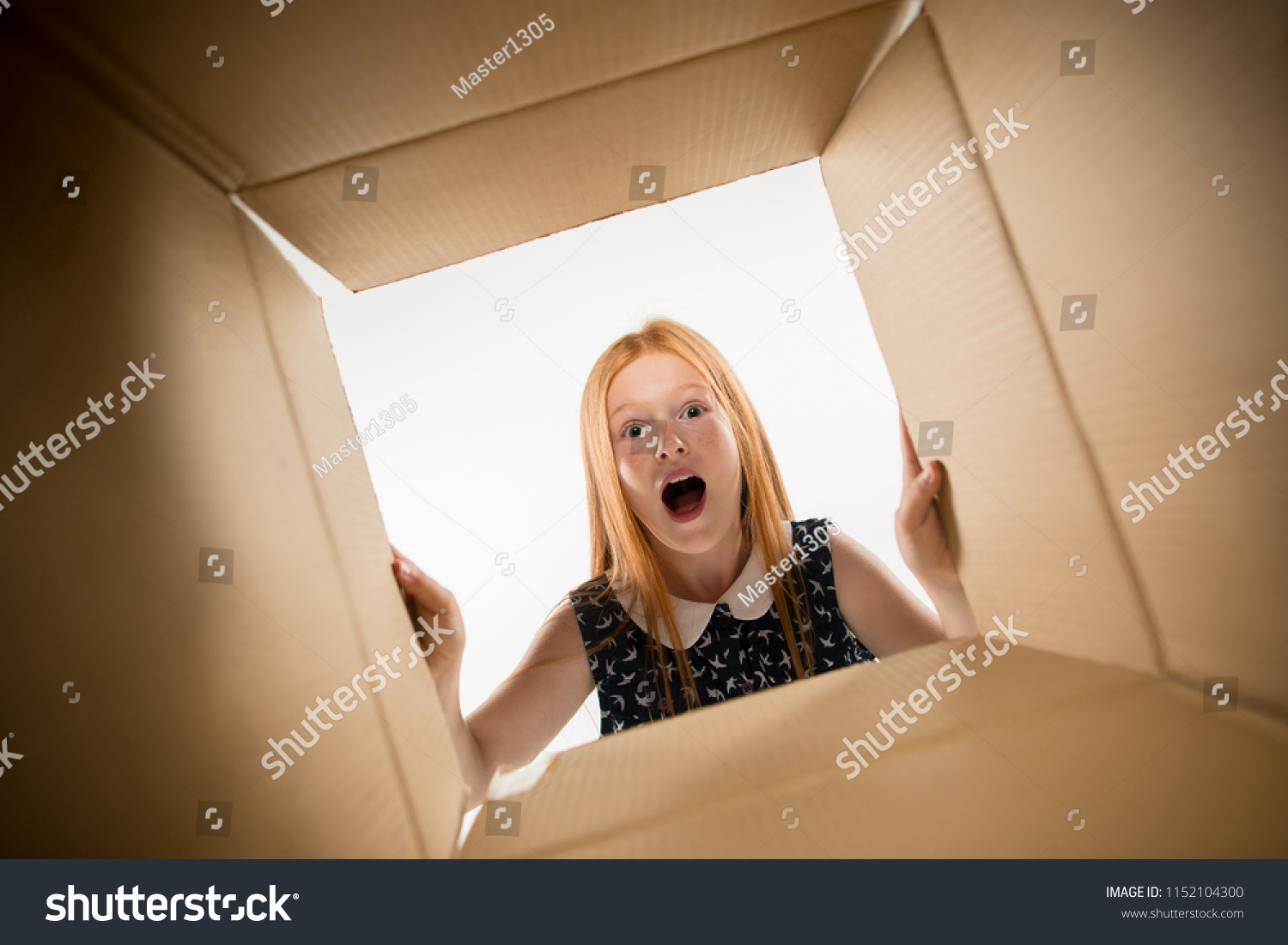The surprised girl unpacking, opening carton box and looking inside. The package, delivery, surprise, gift lifestyle concept. Human emotions and facial expressions concepts #1152104300