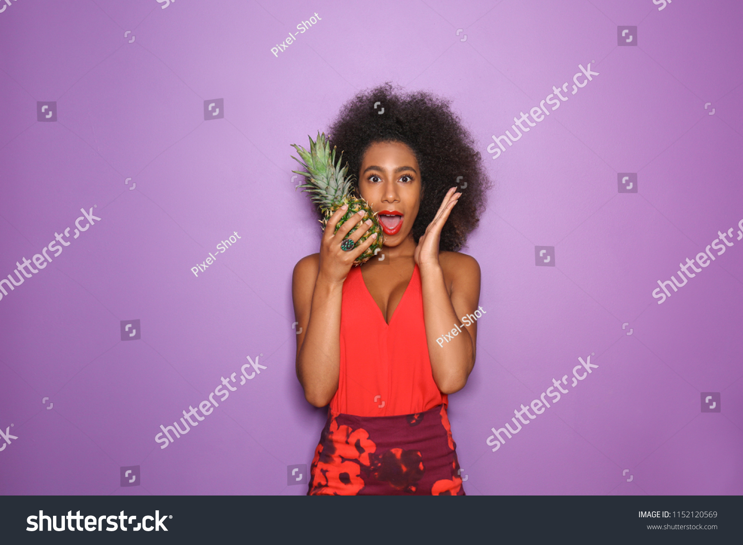 Surprised African-American woman with pineapple on color background #1152120569