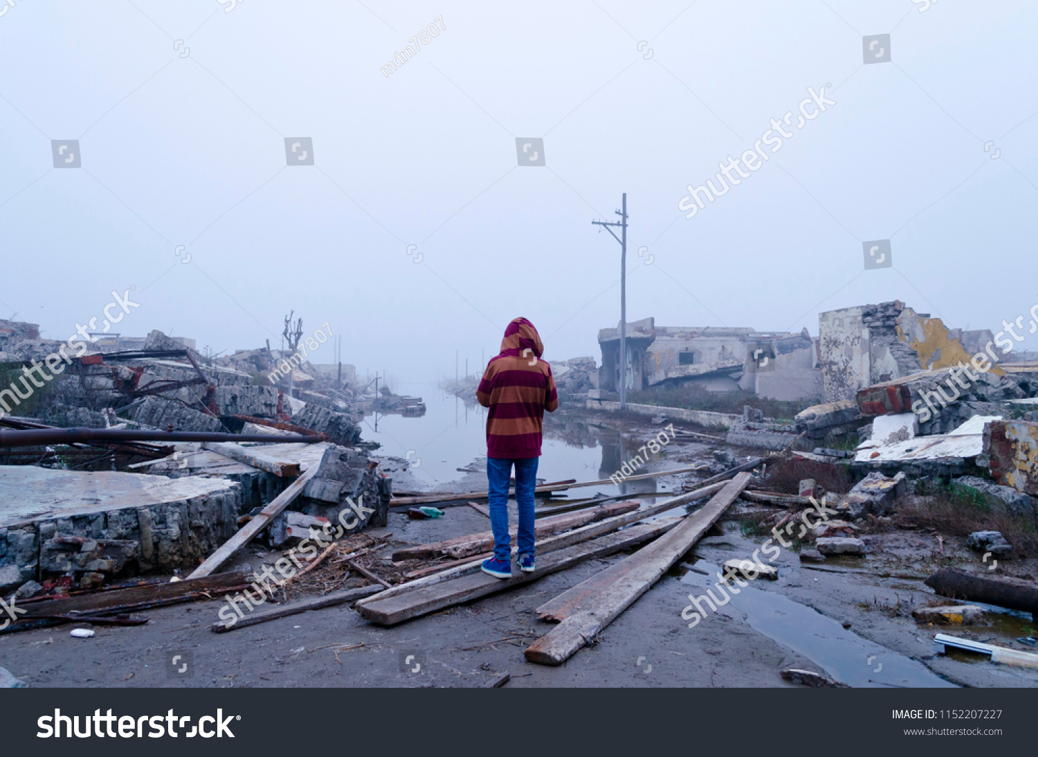 boy watching the flood in Epecuen, Buenos Aires, Argentina. Climate change. Ruins of flooded city. #1152207227