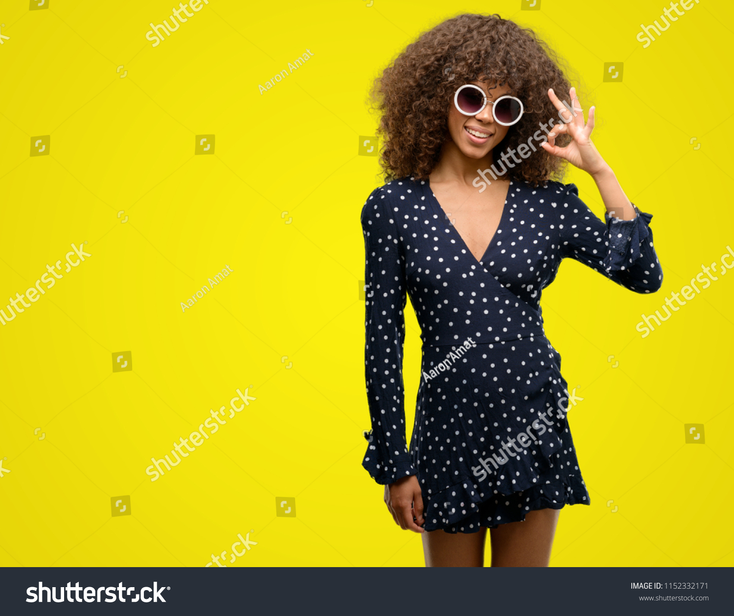 African american woman with sunglasses and summer dress doing ok sign with fingers, excellent symbol #1152332171