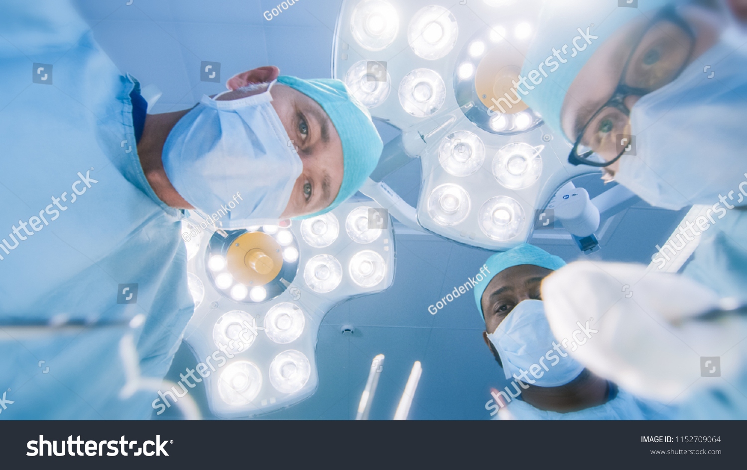 Low Angle Shot POV Patient View: Two Professional Surgeons Holding Surgical Instruments Starting Surgery. #1152709064