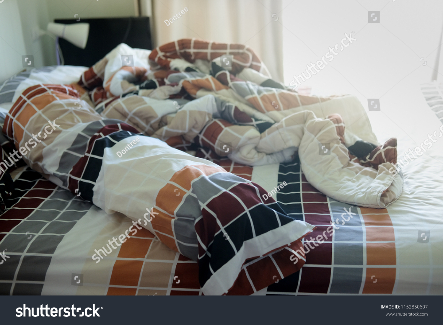 Unmade bed with crumpled bed sheet and pillows after comfort duvet sleep waking up in the morning. #1152850607