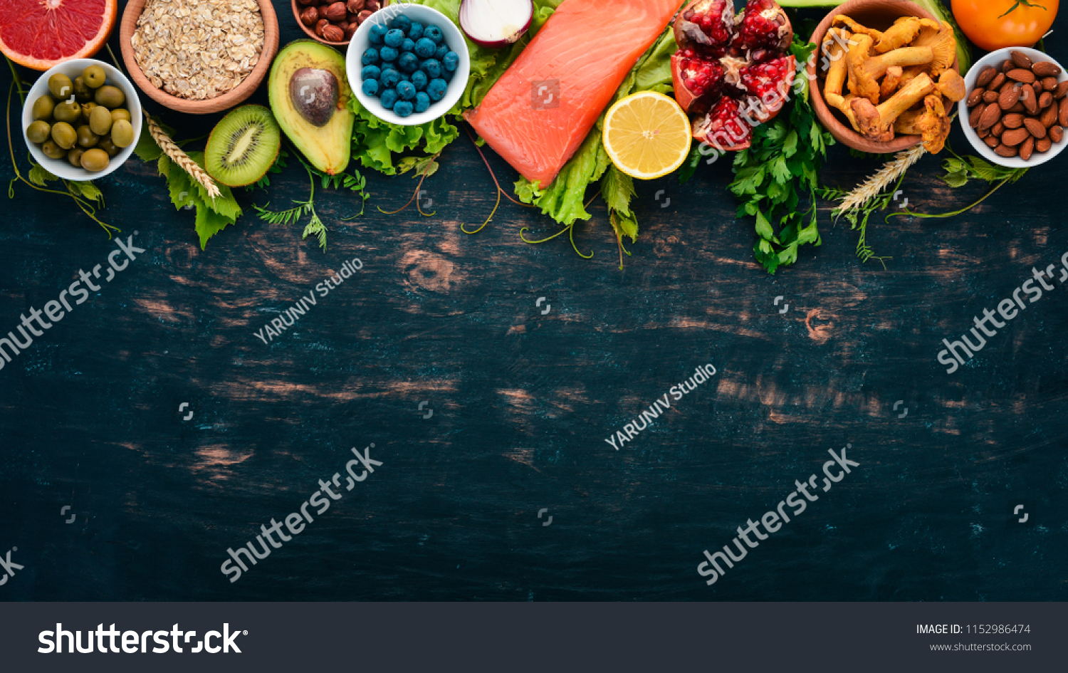 A set of healthy food. Fish, nuts, protein, berries, vegetables and fruits. On a black wooden background. Top view. Free space for text. #1152986474