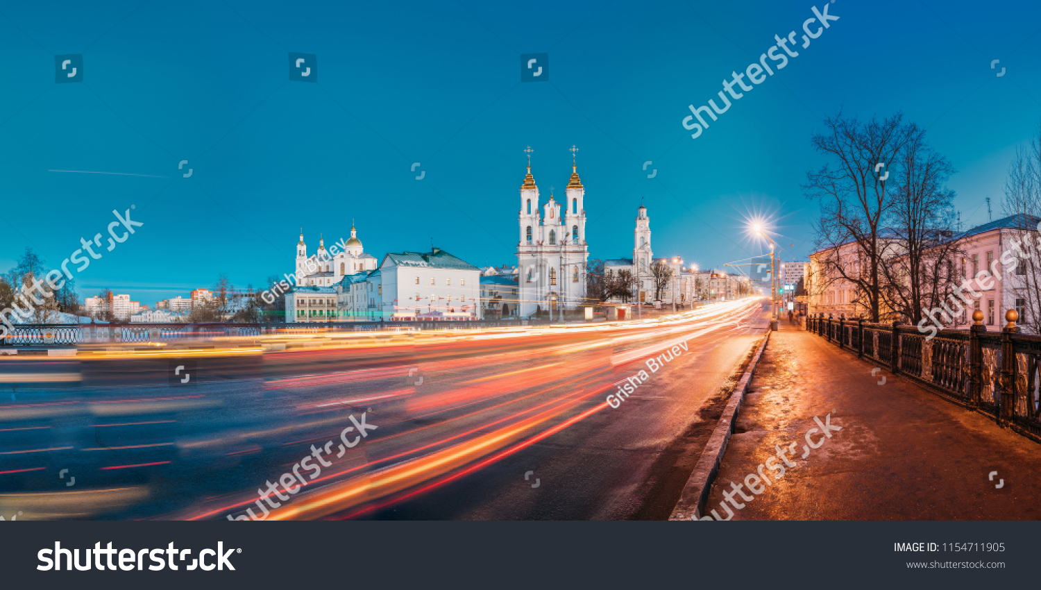 Vitebsk, Belarus. Panorama Of Evening Or Night View Of Famous Landmarks Is Assumption Cathedral, Church Of Resurrection Of Christ And Old Town Hall In Street Lights Illumination. Traffic Light Trails #1154711905