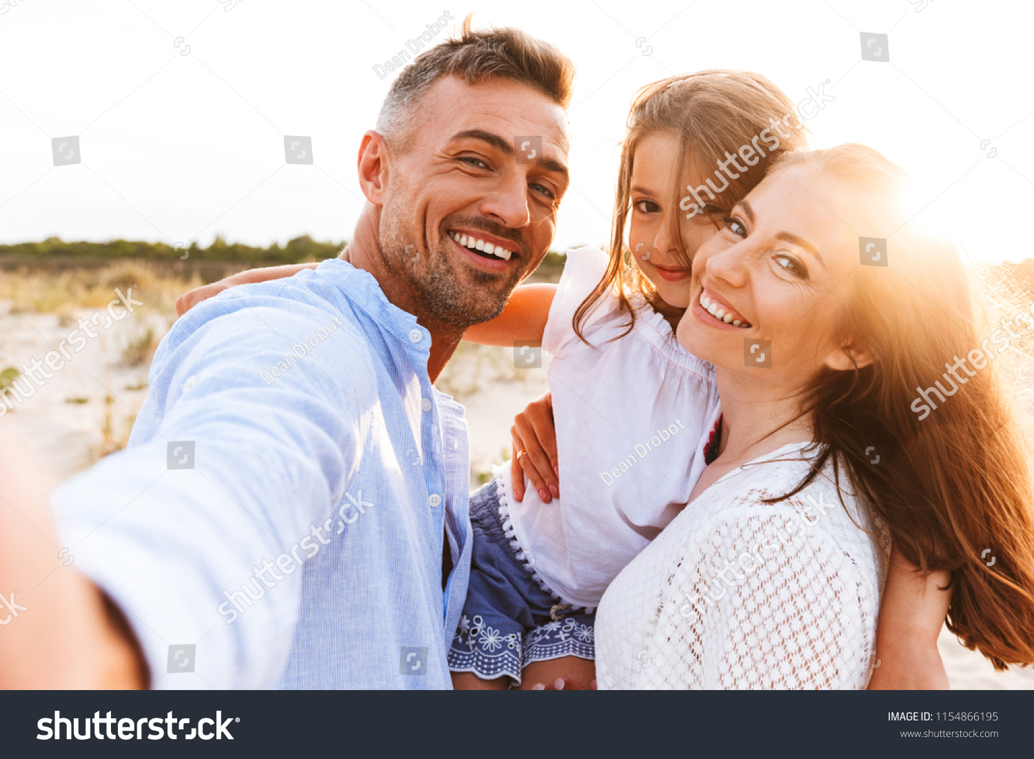 Happy family spending good time at the beach together, taking selfie #1154866195