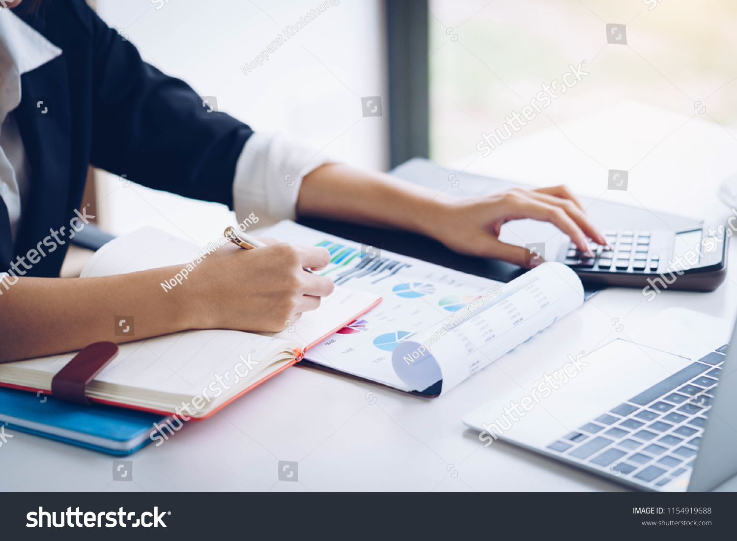 Business woman working with financial data hand using calculator and writing make note with calculate. Business financial and accounting concept. #1154919688