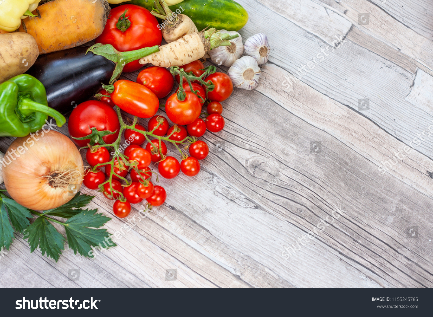 Colourful variety of fresh home grown vegetables from an organic garden on a wooden surface. Tomato, green and yellow bell peppers, carrot, parsley, onion, garlic, potato, eggplant and zucchini. #1155245785