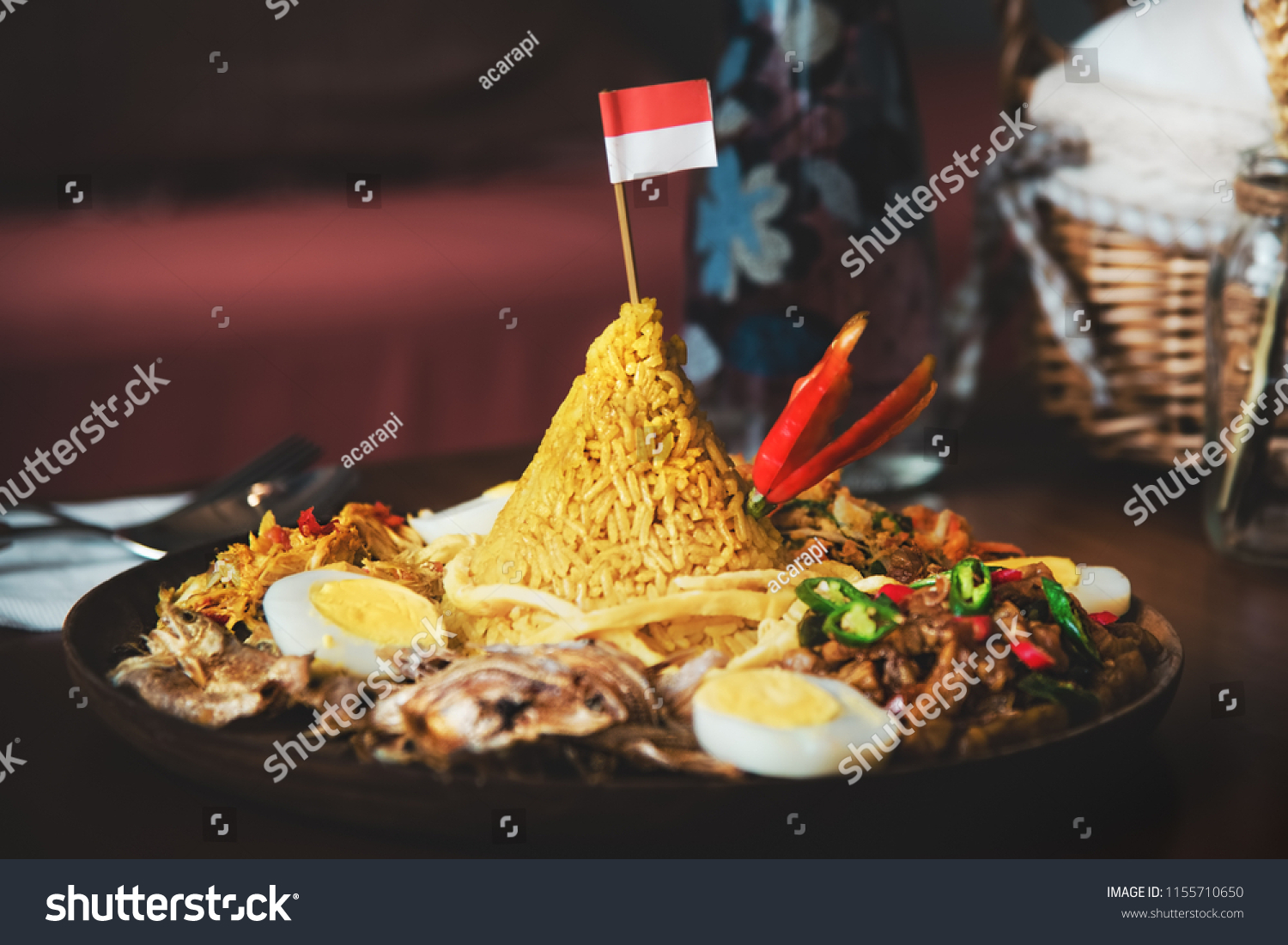 Traditional Indonesian Cuisine Nasi Tumpeng for Independence Celebration with Flag. Tumpeng is a cone-shaped rice dish like mountain with meats usually eat as breakfast or lunch
 #1155710650