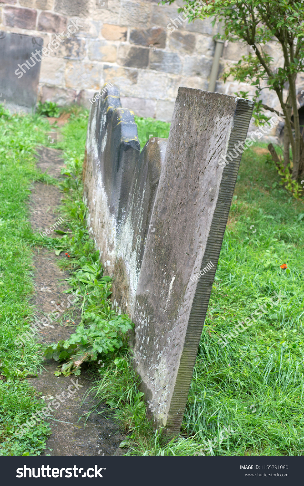 Leaning gravestones in a chruch graveyard #1155791080