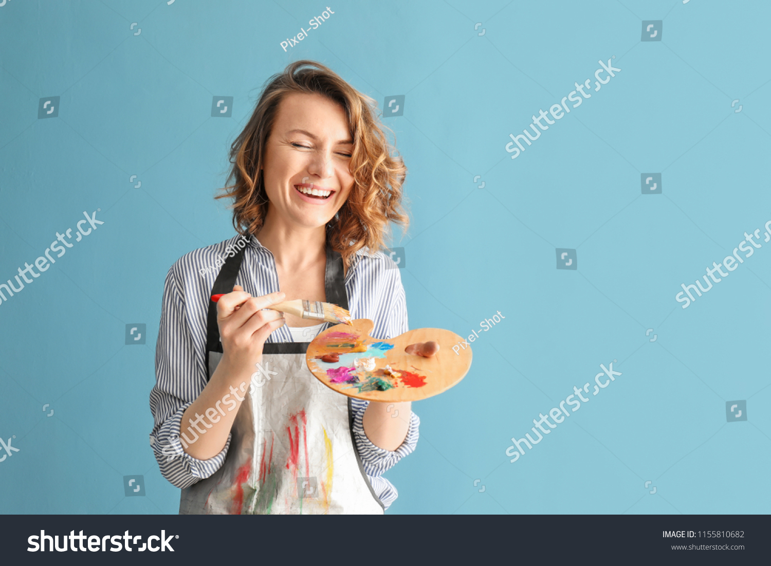 Female artist with brush and paint palette on color background #1155810682