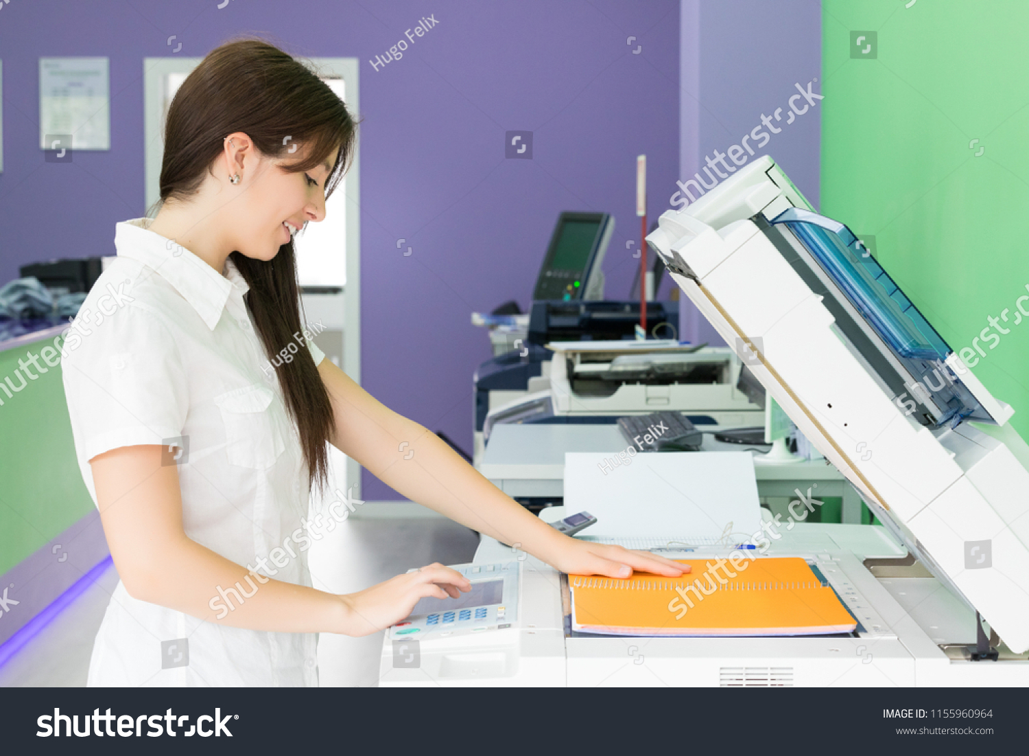 A young student at a copy center taking some copies for her final exams  #1155960964