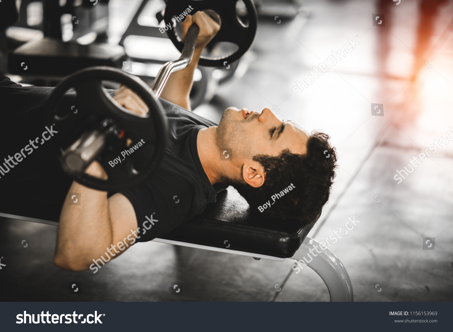 Fit caucasian handsome young man and big muscle in sportswear. Young man holding dumbbell during an exercise class in a gym. Healthy sports lifestyle, Fitness concept. with copy space for your text. #1156153969