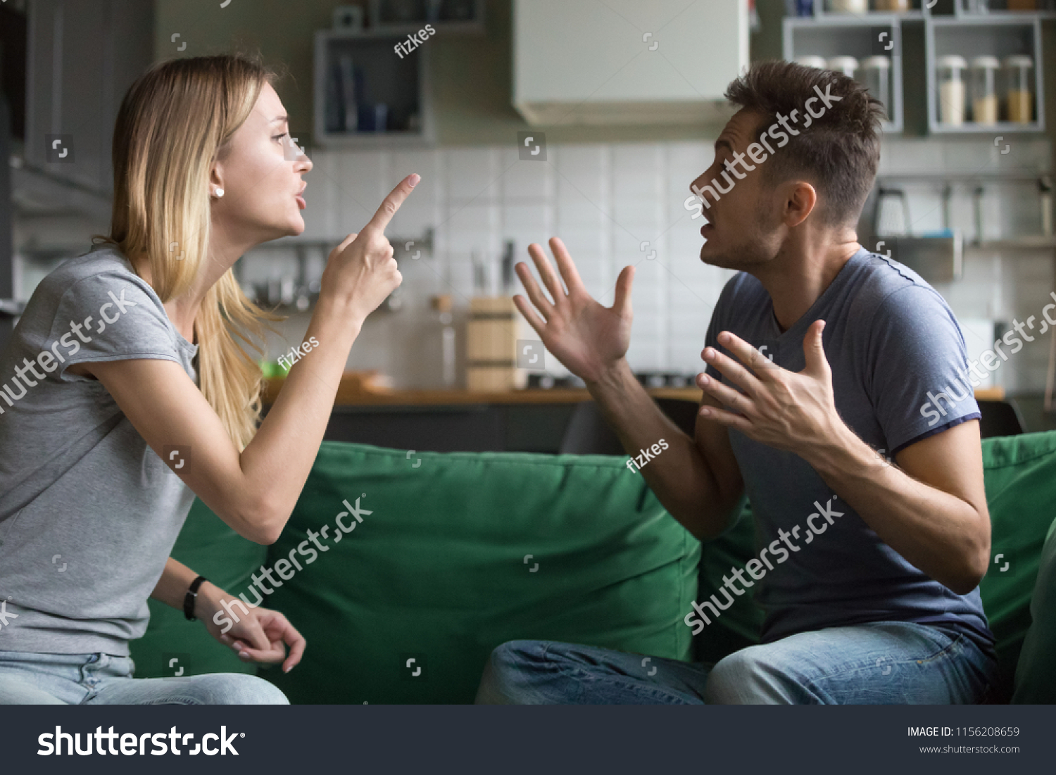 Angry millennial couple arguing shouting blaming each other of problem, frustrated husband and annoyed wife quarreling about bad marriage relationships, unhappy young family fighting at home concept #1156208659