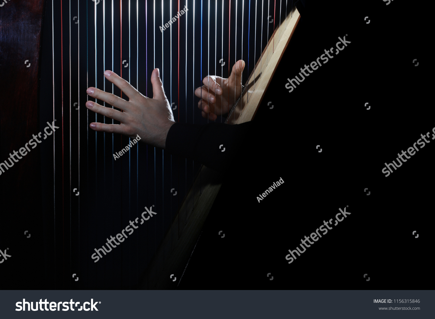 Harp player. Hands playing Irish harp strings. Music instrument closeup. Harpist with celtic harp #1156315846