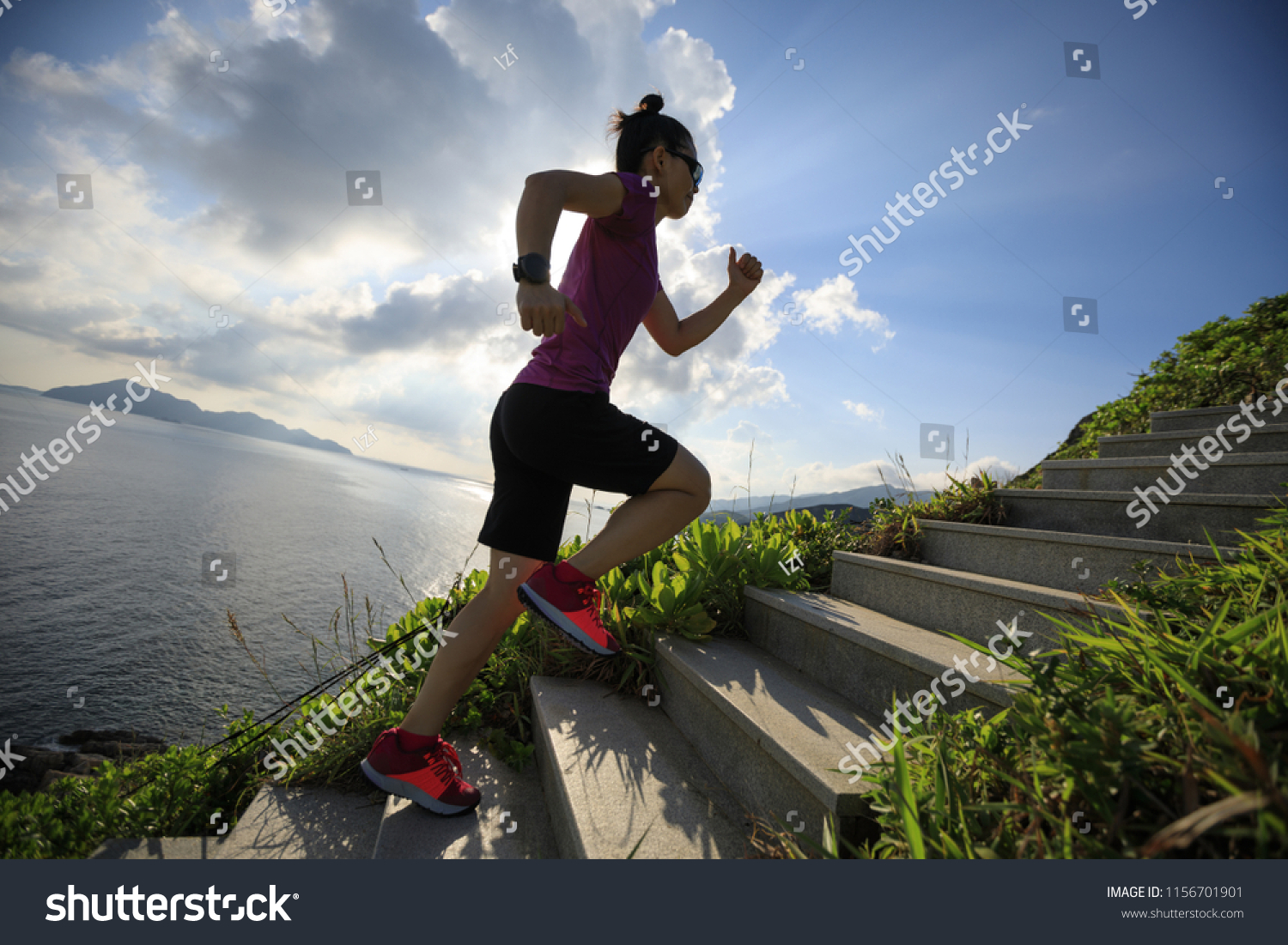 Woman ultra marathon runner running up on seaside mountain stairs #1156701901