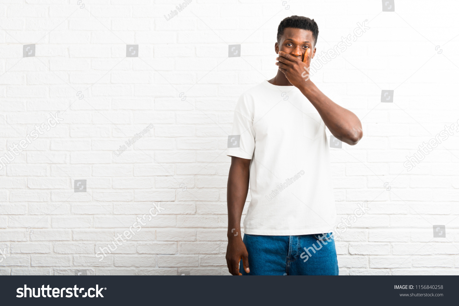 Dark skinned man covering mouth with hands for saying something inappropriate. Can not speak #1156840258