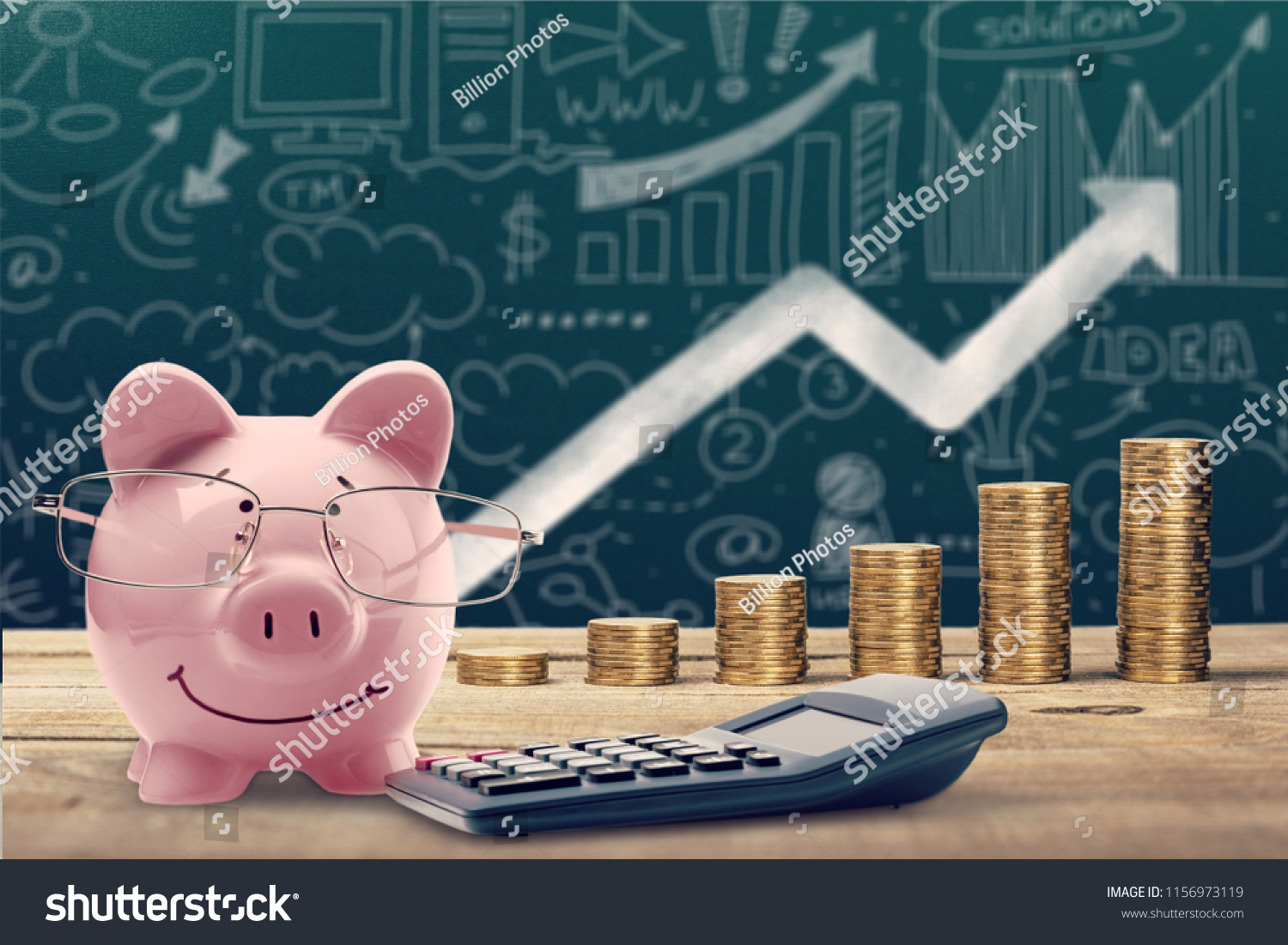 Piggy bank, calculator and coins on wooden #1156973119
