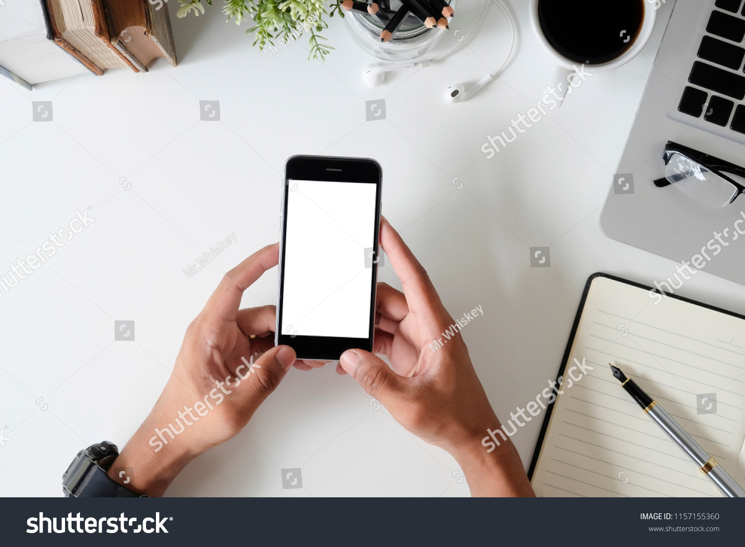 Top view office desk with mockup smartphone on hands with empty display screen. #1157155360