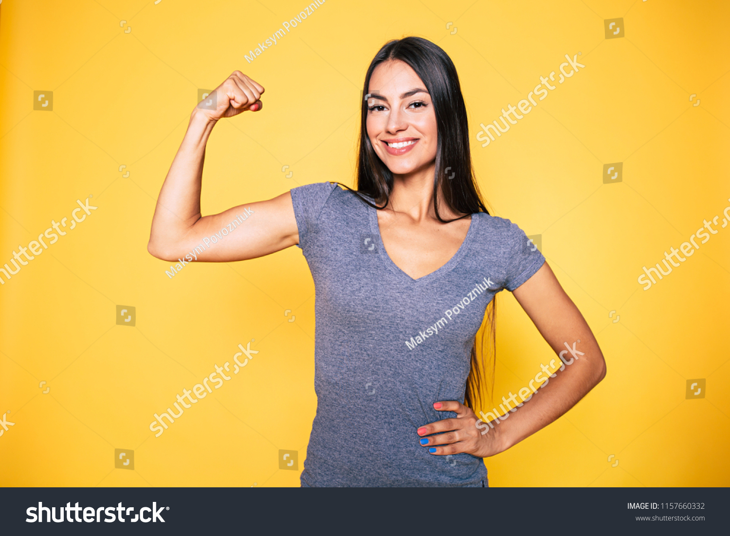 Sport, healthy lifestyle, gym, good body condition, women health, fitness concepts. Close up Portrait of Young cute sporty smiling brunette woman while she shows her arms and biceps on camera #1157660332