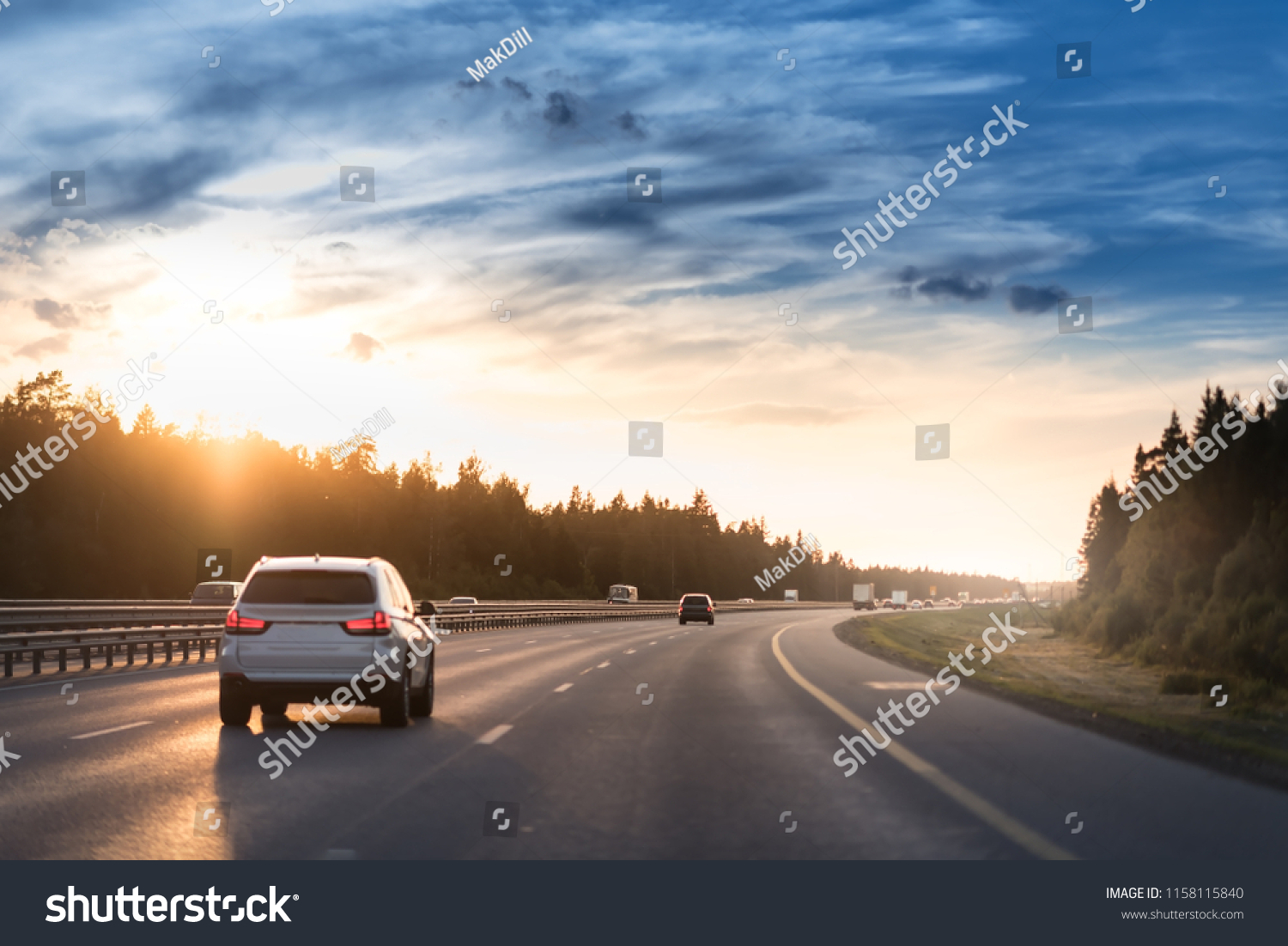 Highway traffic in sunset. Road with metal safety barrier or rail. cars on the asphalt under the cloudy sky. #1158115840