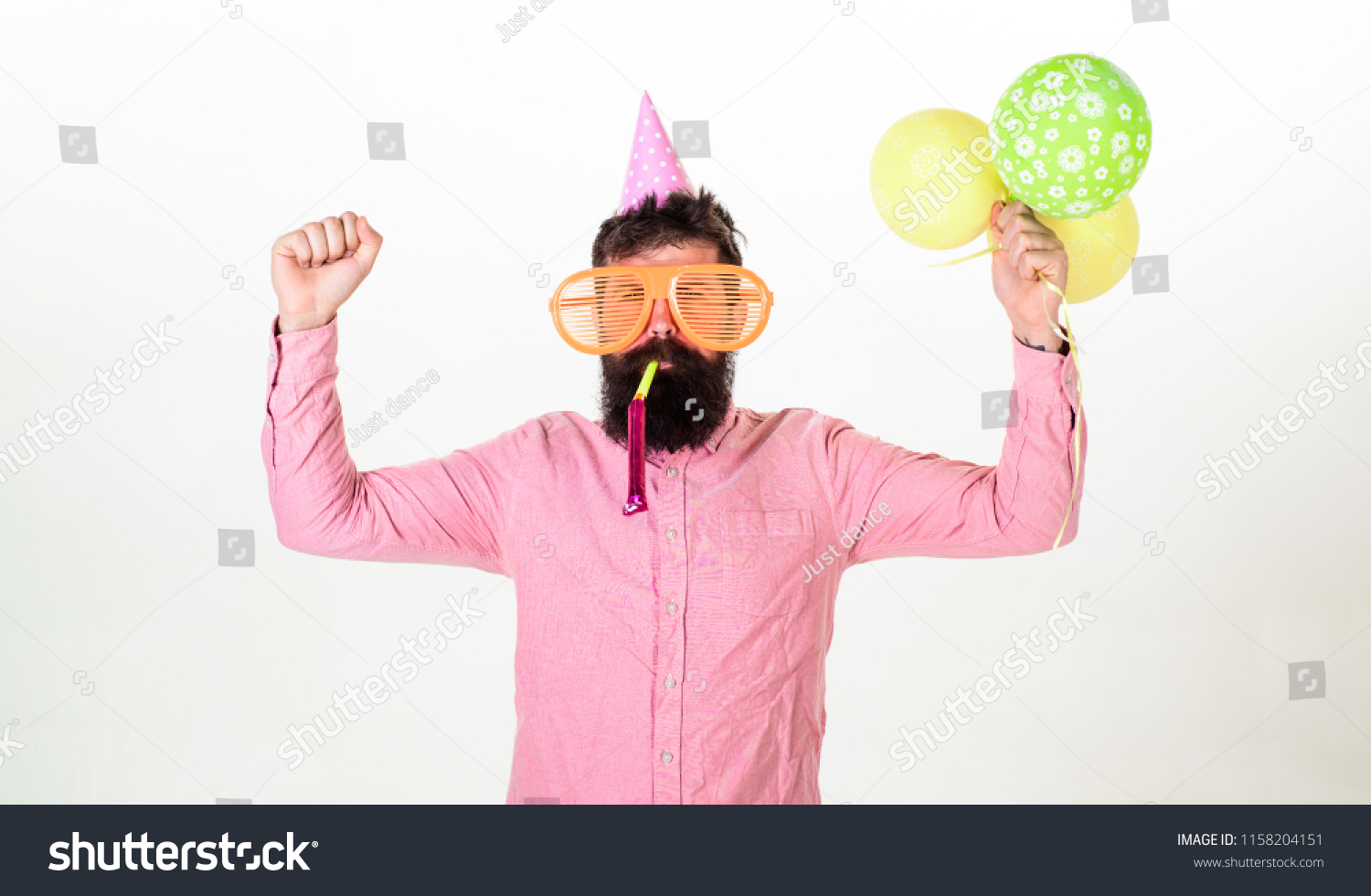 Celebration concept. Man with beard and mustache on busy face blows into party horn, white background. Hipster in giant sunglasses celebrating birthday. Guy in party hat with air balloons celebrates. #1158204151