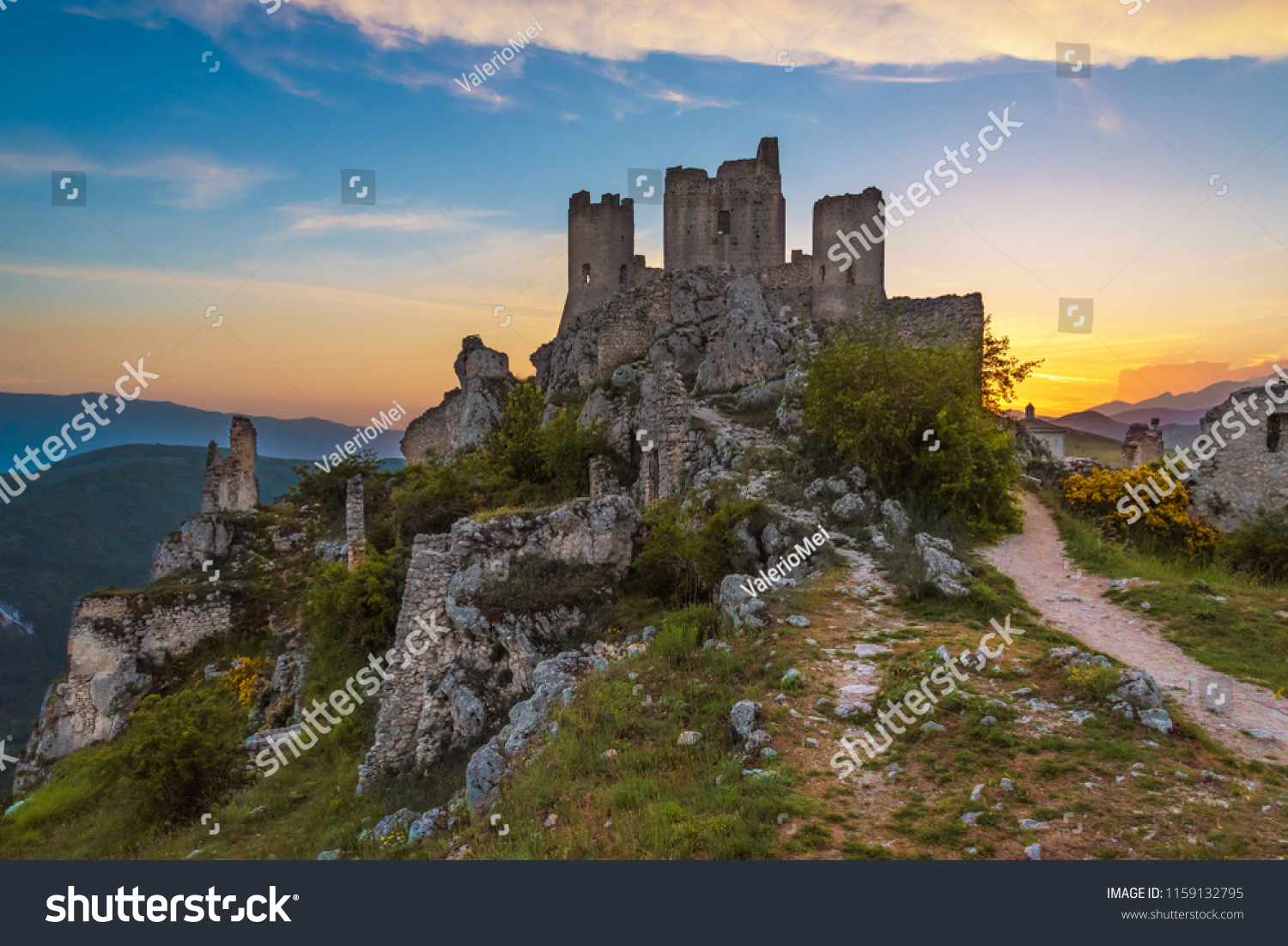Rocca Calascio (Italy) - The ruins of an old medieval village with castle and church, over 1400 meters above sea level on the Apennine mountains in the heart of Abruzzo, at sunset. #1159132795