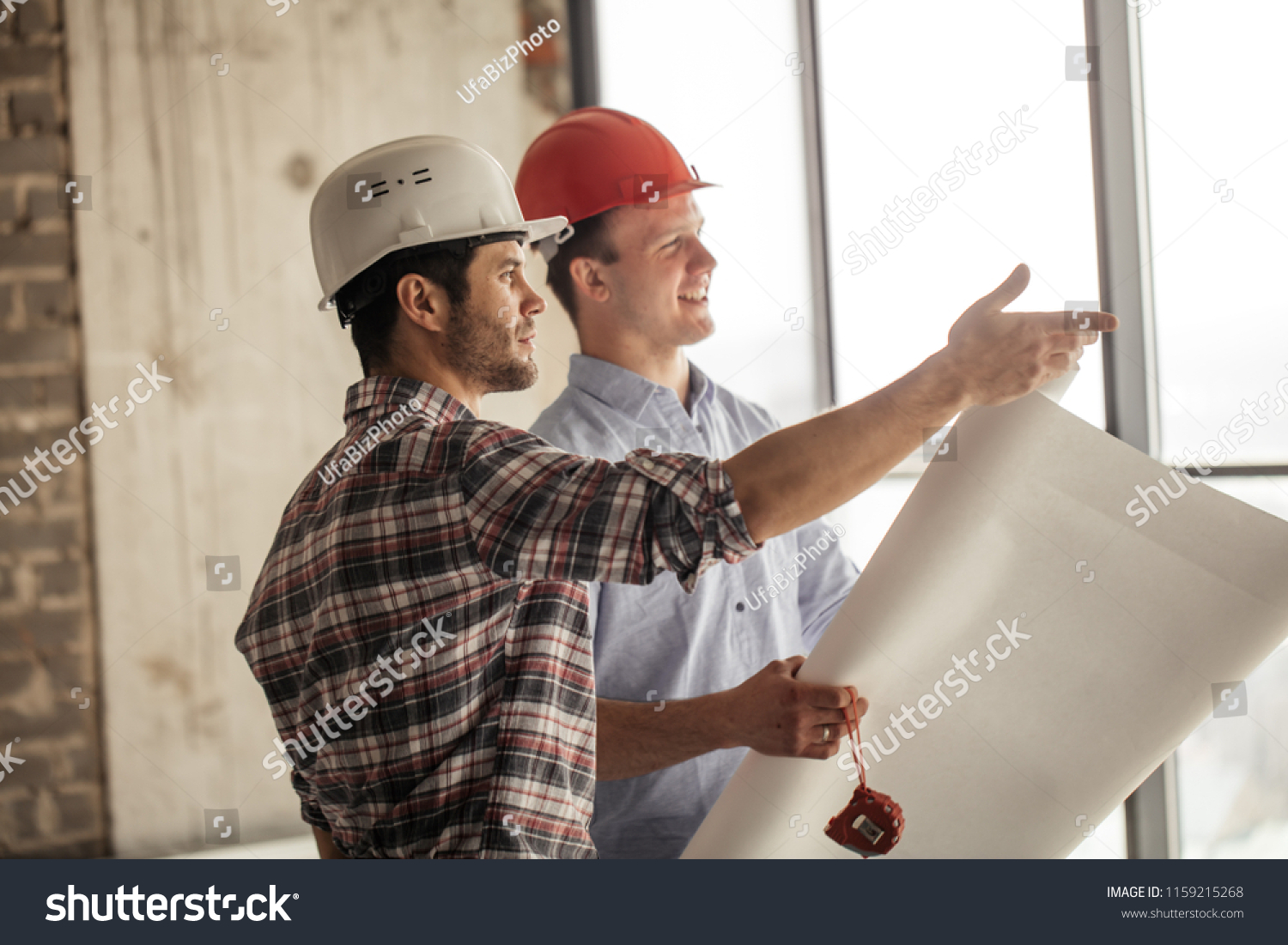 positive worker is showing the the progress of construction to a leader #1159215268