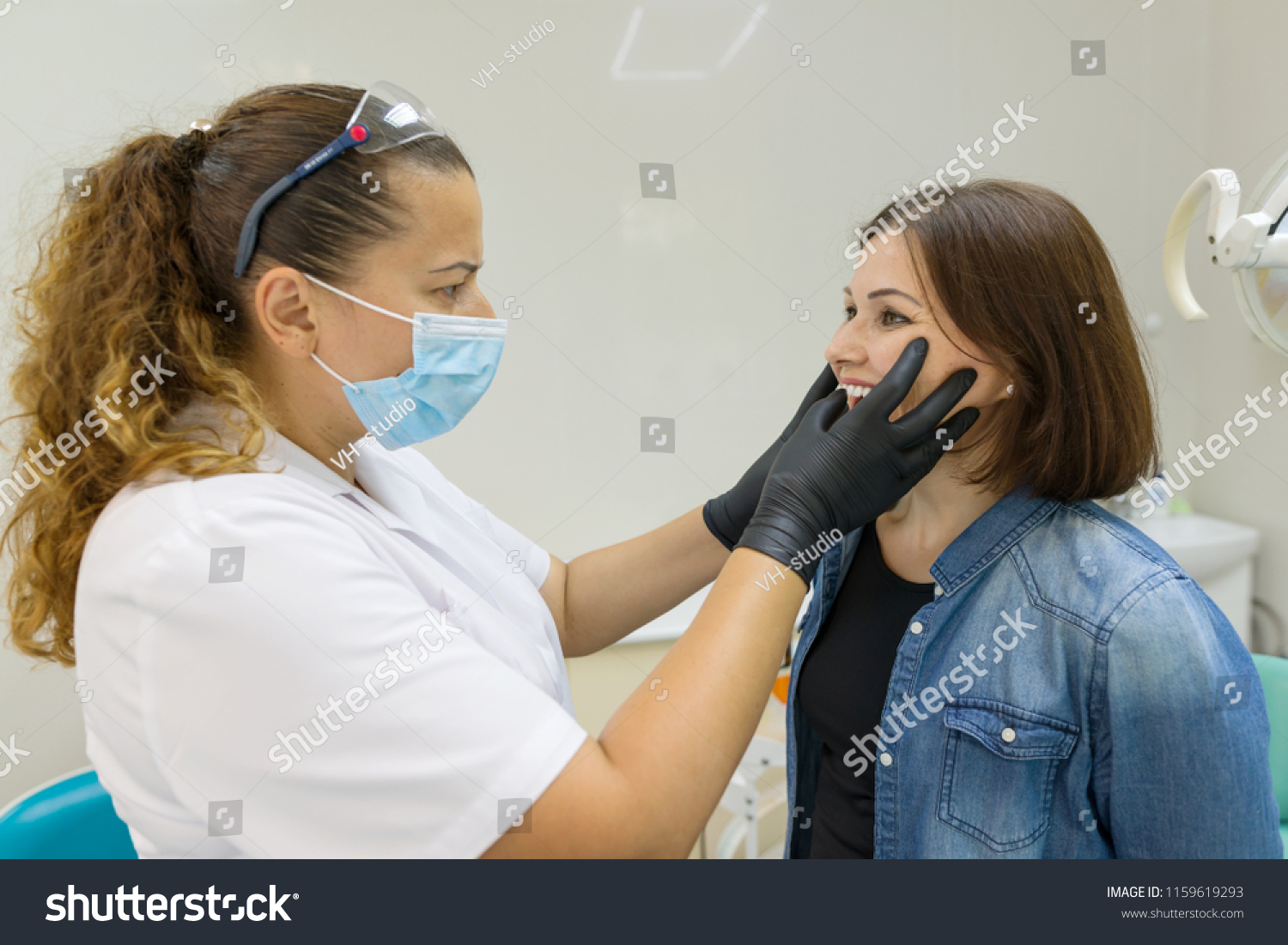 Adult woman suffering from toothache and complaining during visit to professional dentist #1159619293