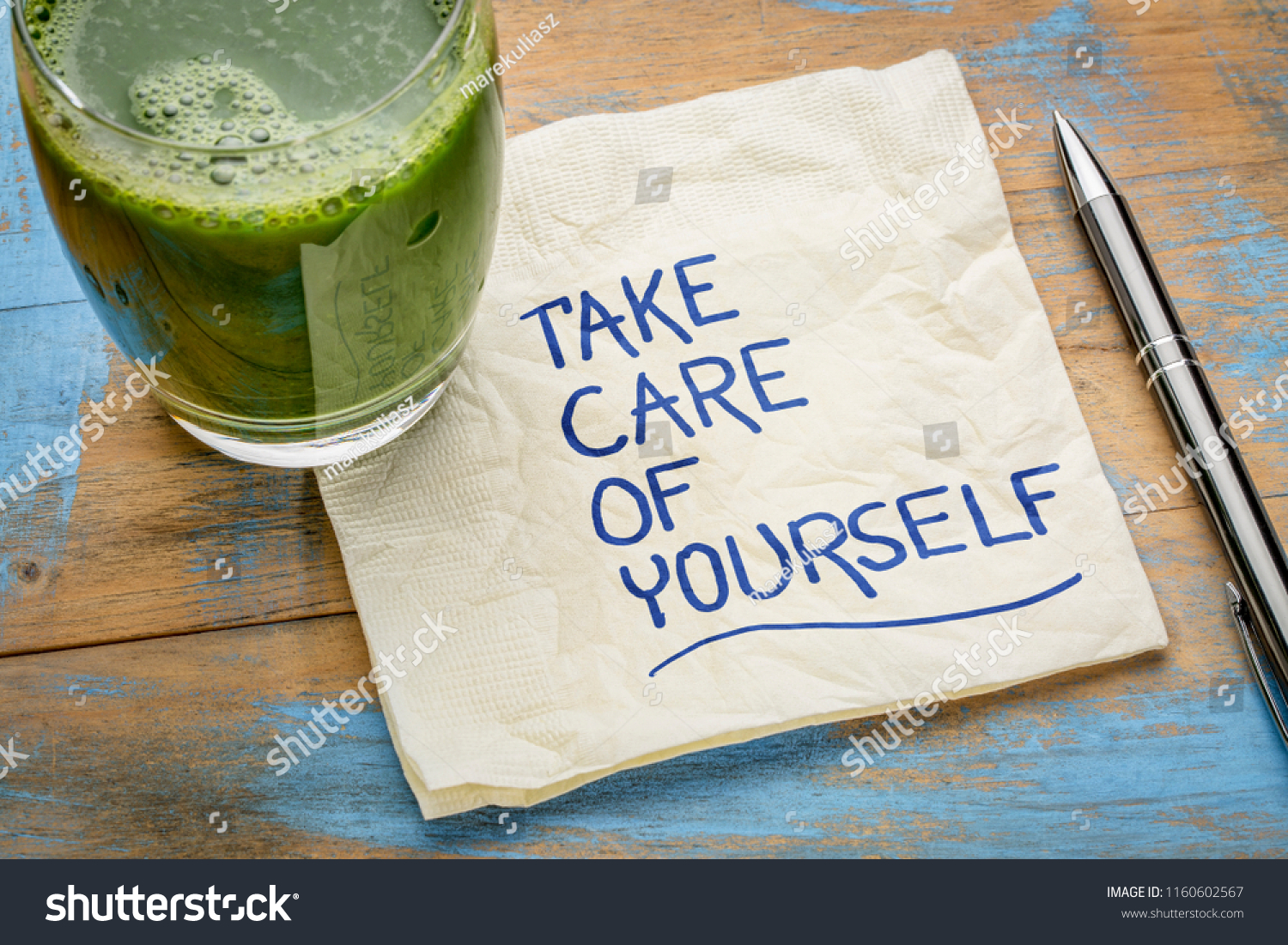 take care of yourself - inspirational handwriting on a napkin with a glass of green juice #1160602567