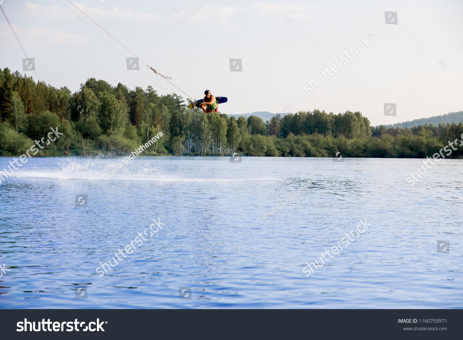 Young man riding wakeboard on a lake #1160759971