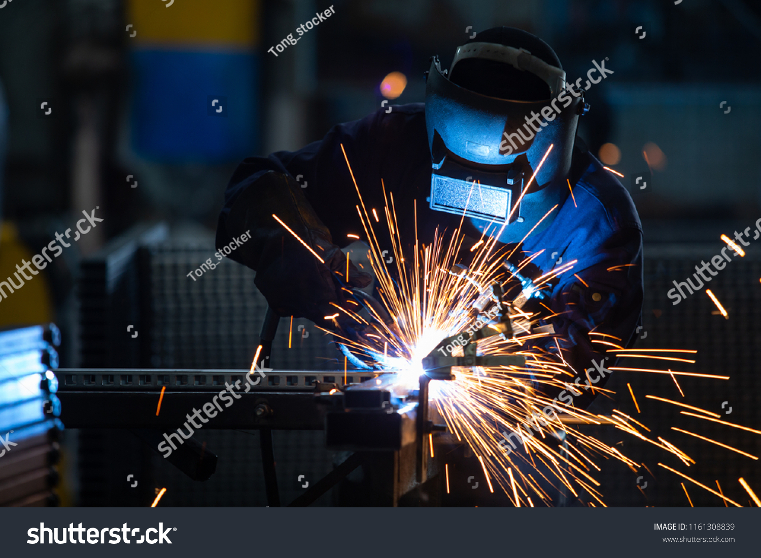 Workers wearing industrial uniforms and Welded Iron Mask at Steel welding plants, industrial safety first concept. #1161308839