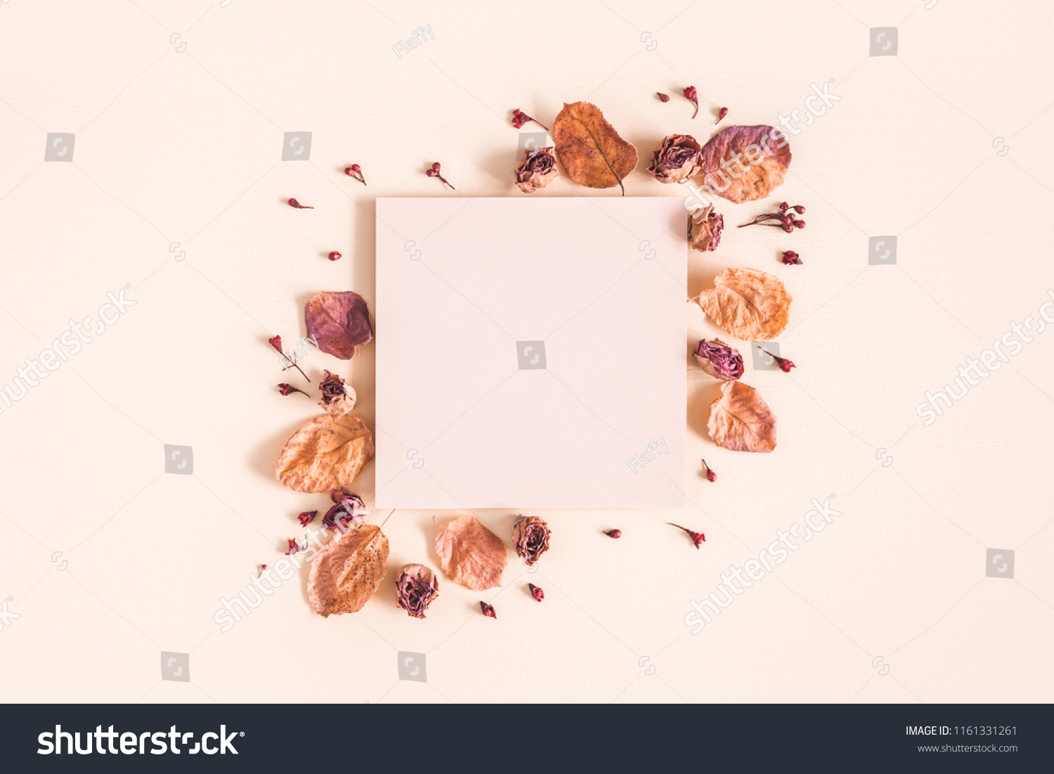 Autumn composition. Paper blank, dried flowers and leaves on pastel beige background. Autumn, fall concept. Flat lay, top view, copy space #1161331261