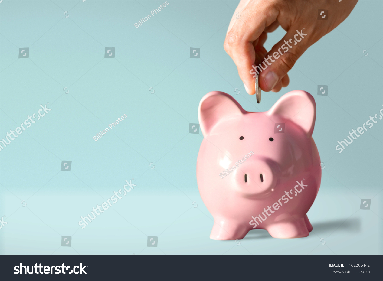 Hand putting coin to piggy bank #1162266442