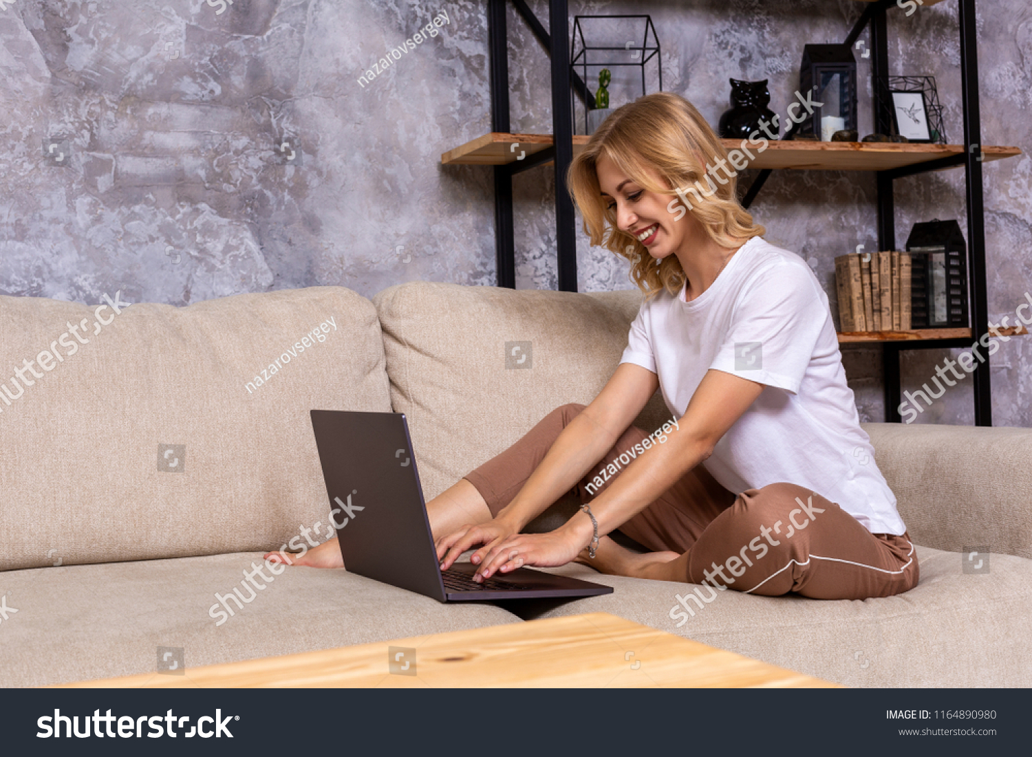 Young beautiful woman using laptop computer smiling happy watching and browsing or doing online internet shopping at home. #1164890980