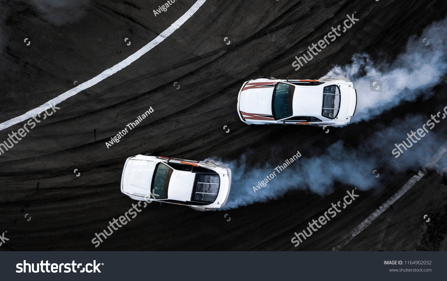 Aerial top view two car drift battle on asphalt race track, Automobile and automotive car view from above, Professional car drifting, Race drift car with white smoke from burning tires on speed track. #1164902032