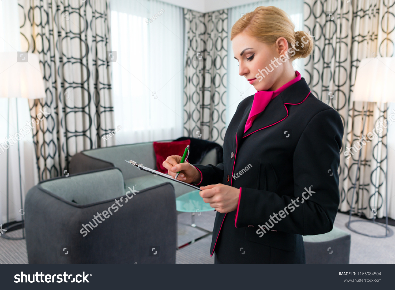 Housekeeping manager or assistant controlling hotel suit or suit with checklist on tidiness  #1165084504