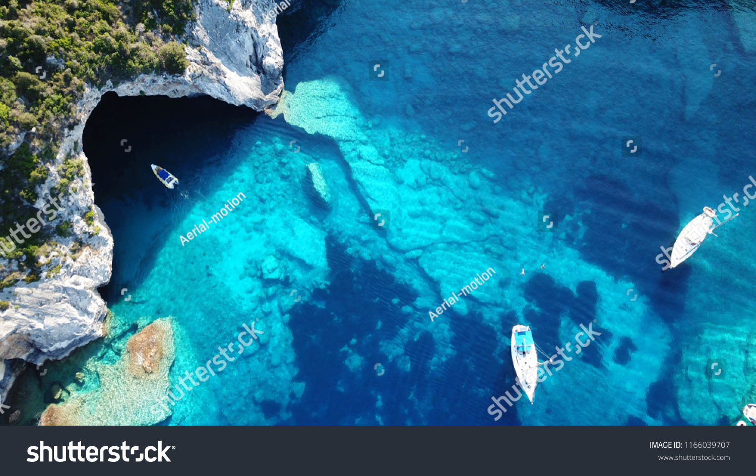 Aerial drone photo of sail boats anchored in tropical Caribbean island paradise bay with white rock caves and turquoise clear sea #1166039707