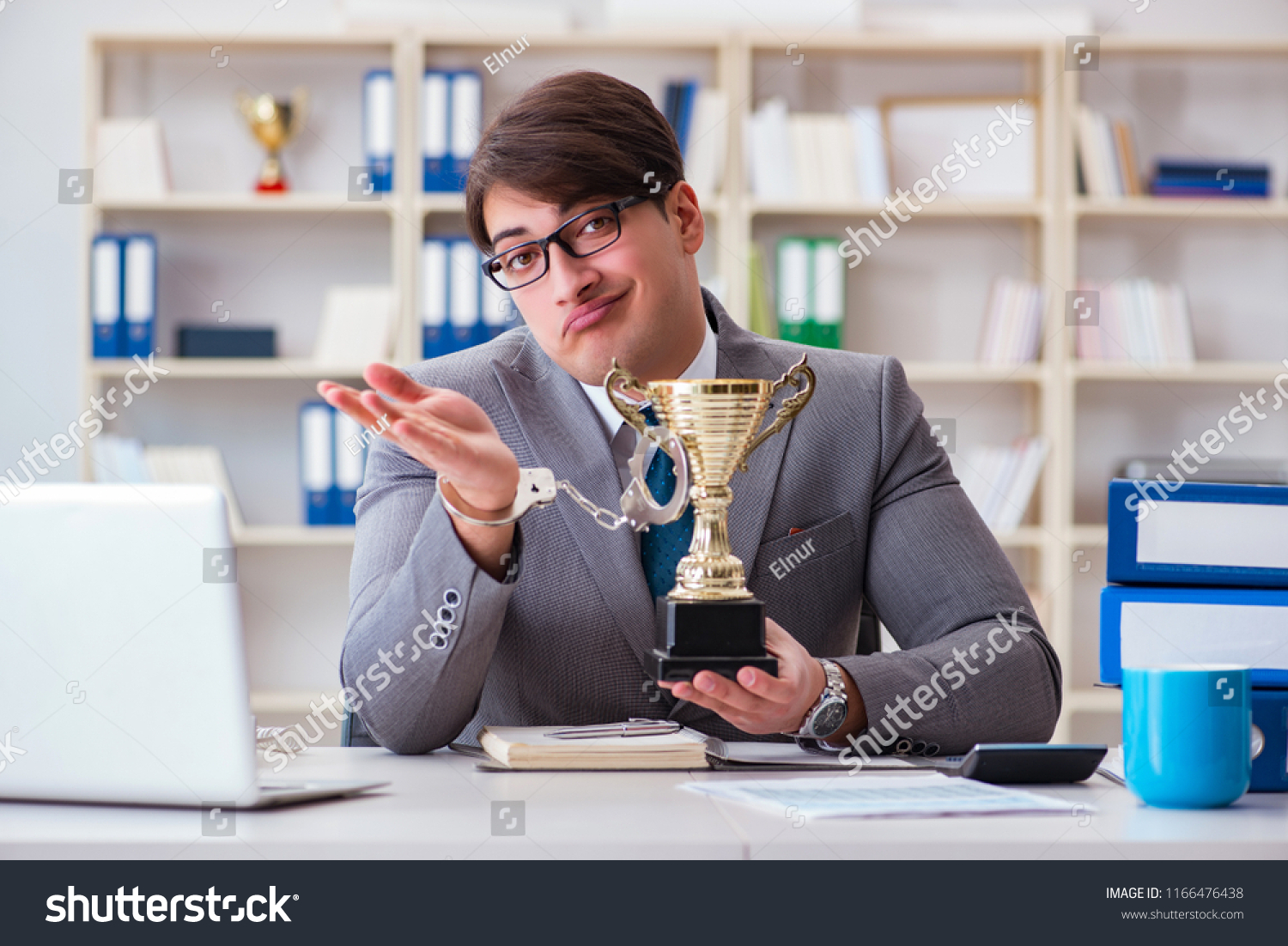 Businessman with golden cup in the office #1166476438