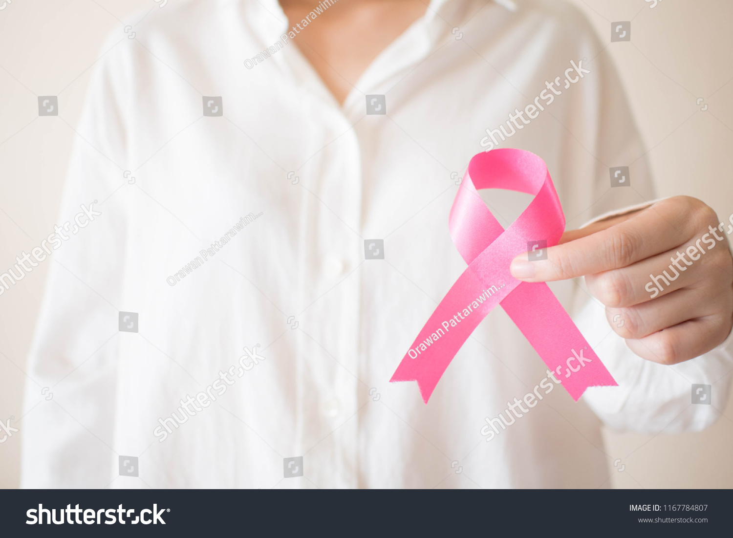 Breast Cancer Awareness Month in October. Close up of female hands holding pink ribbon awareness for support people who live w/ breast cancer. Women's health care and medical concept. Copy space. #1167784807