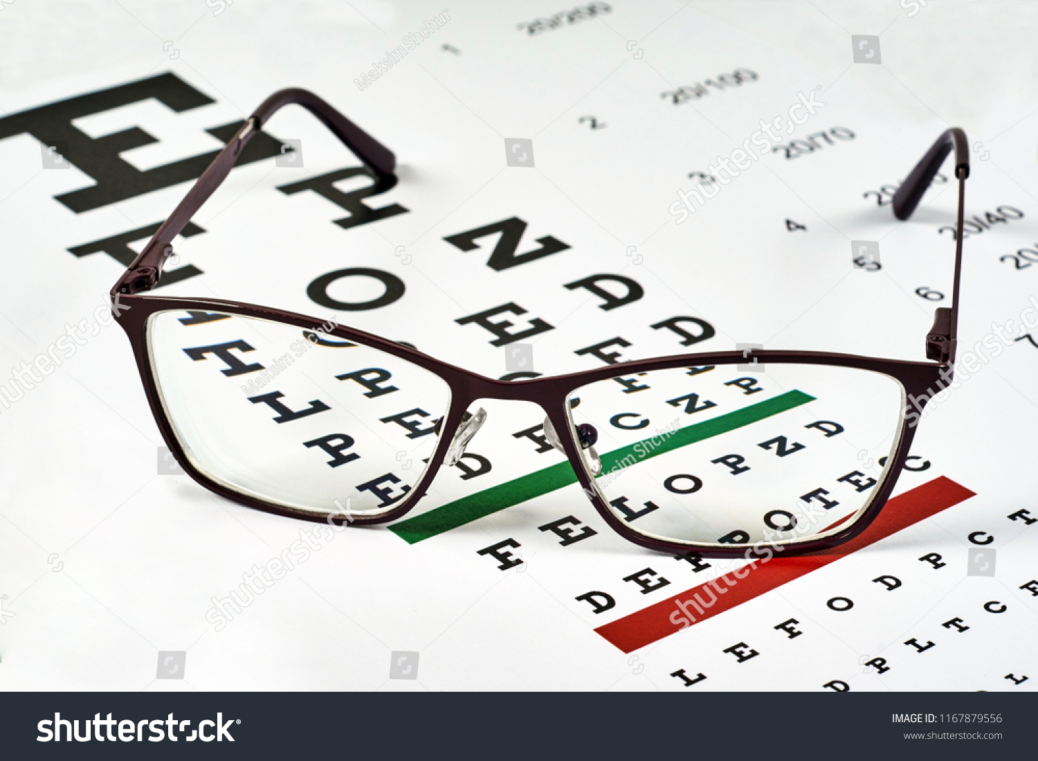 corrective glasses on the background of the Snellen chart #1167879556