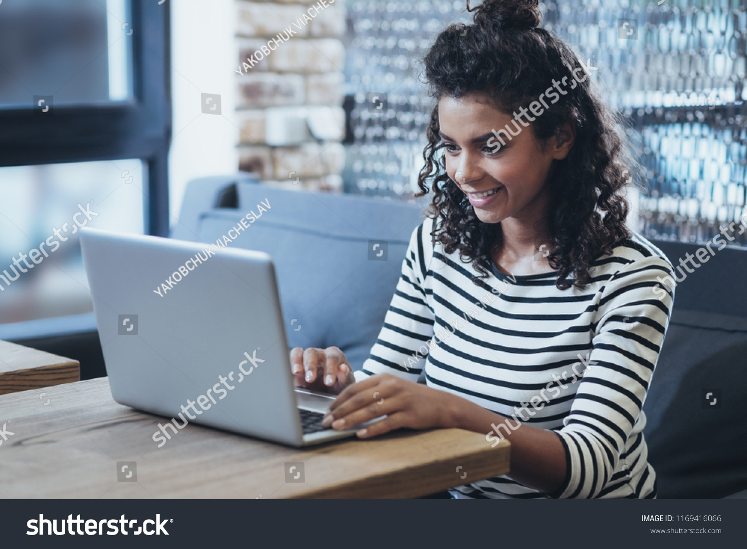 Modern work. Gay female freelancer typing while smiling #1169416066