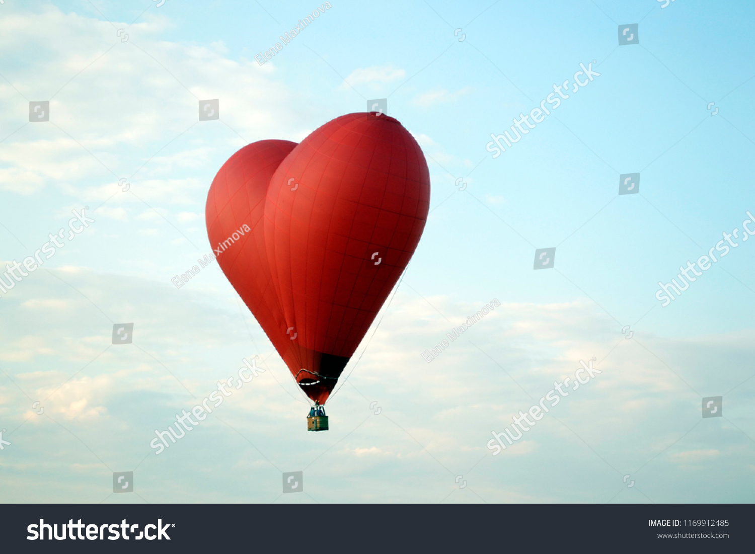 

A balloon in the form of a heart is floating in the sky #1169912485