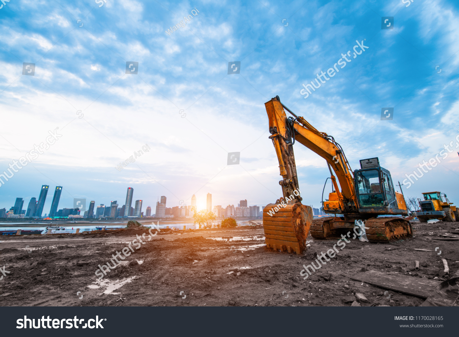 excavator in construction site on sunset sky background #1170028165