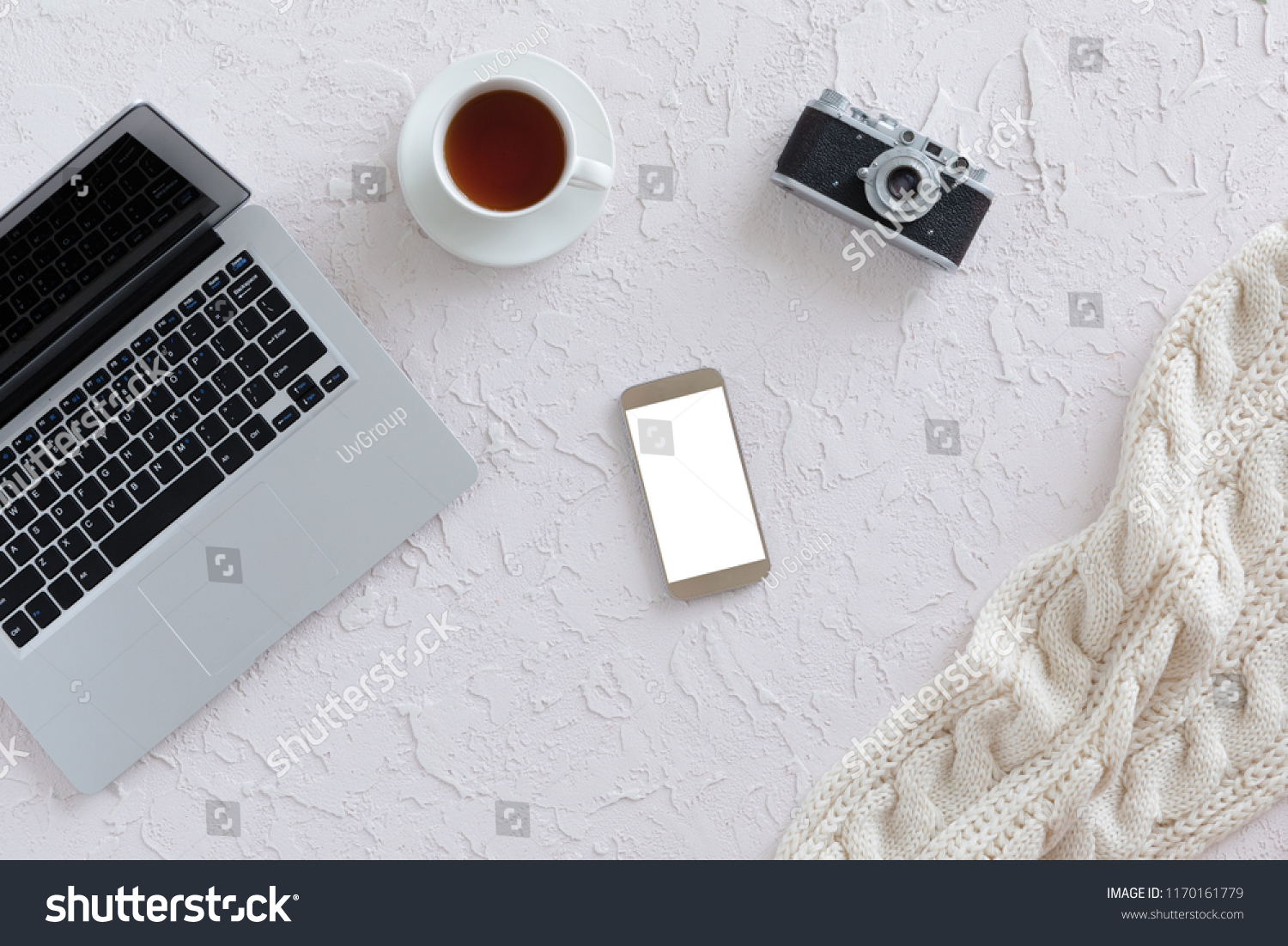 Top view of white office desk with laptop, cup of tea, vintage photo camera and smartphone with isolated screen. Free space for text, business office flat lay concept #1170161779