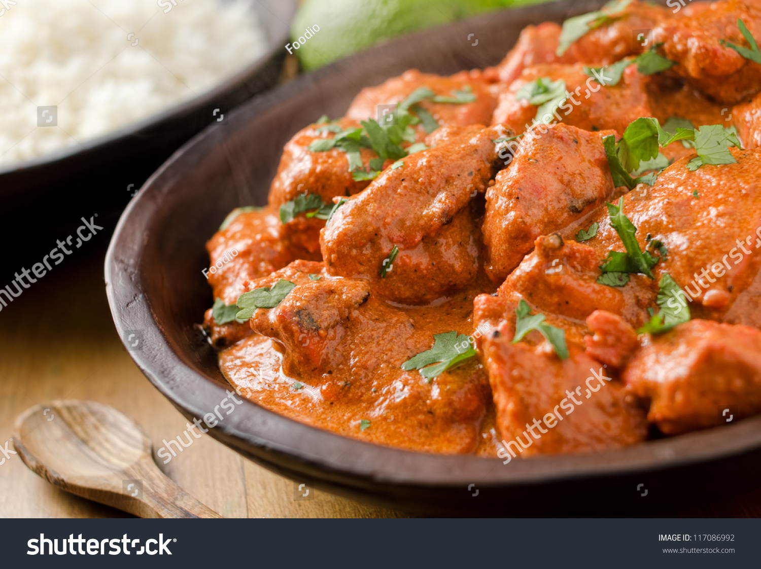 Butter chicken curry with basmati rice and limes. #117086992