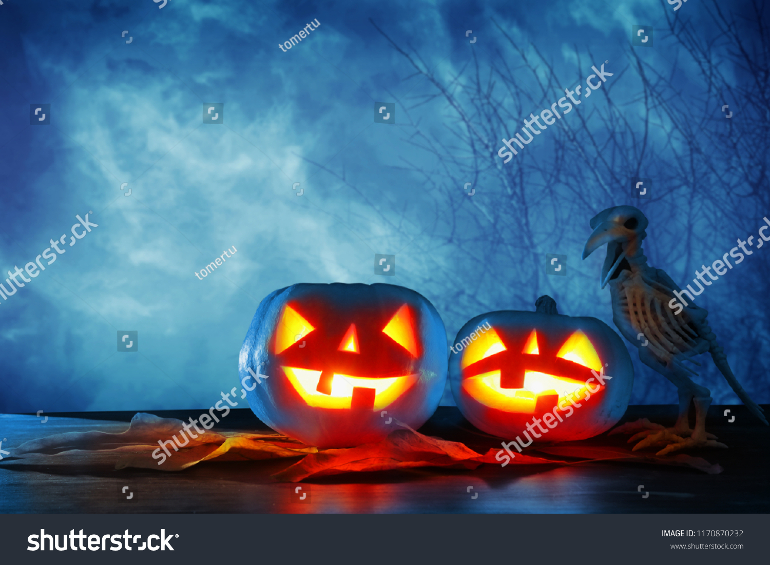 Halloween holiday concept. Pumpkins over wooden table at night scary, haunted and misty forest #1170870232