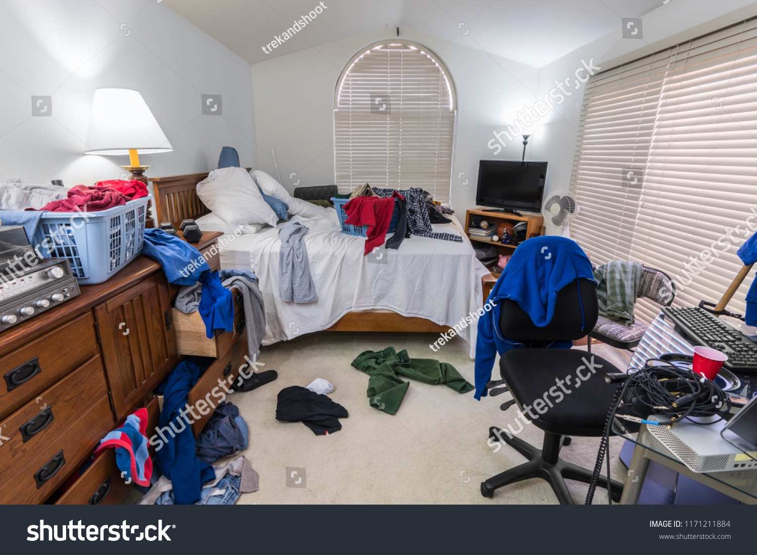 Messy, cluttered teenage boy's bedroom with piles of clothes, music and sports equipment.   #1171211884