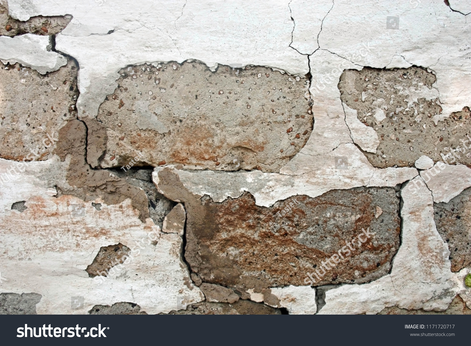Old damaged brick walll with peeling white plaster. Front view. Texture. #1171720717