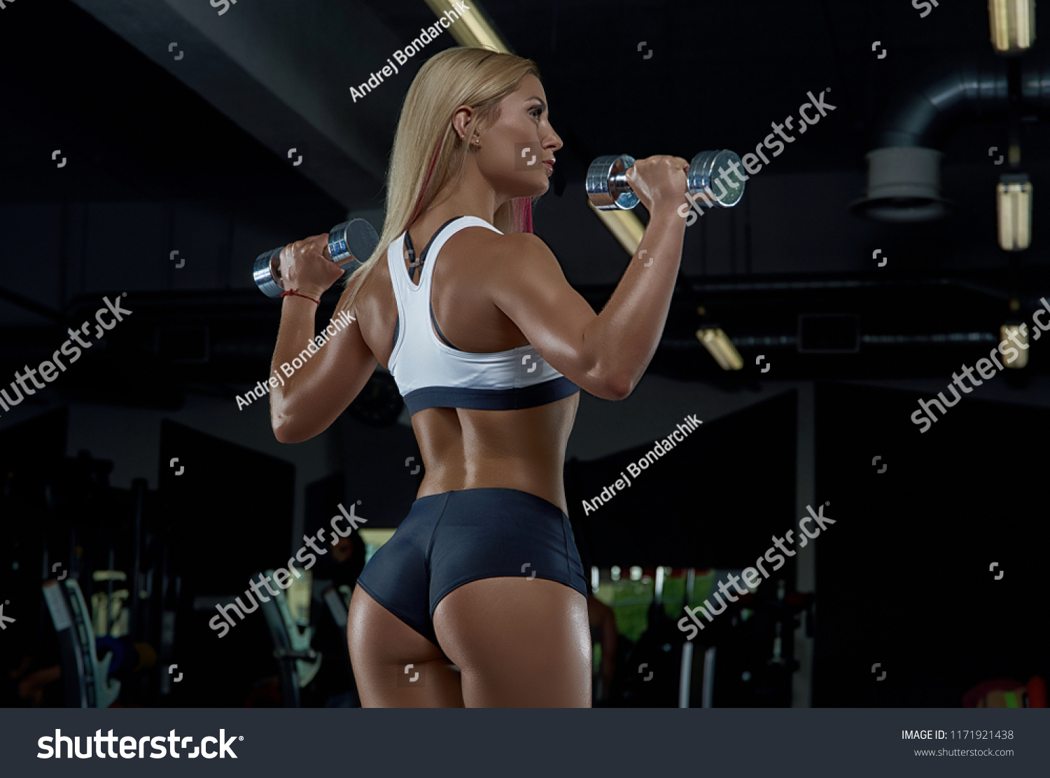 A young smart girl posing in the gym. Dark background. #1171921438